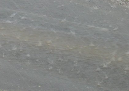 Hail stones plopping in the river created by the rain running down this alley