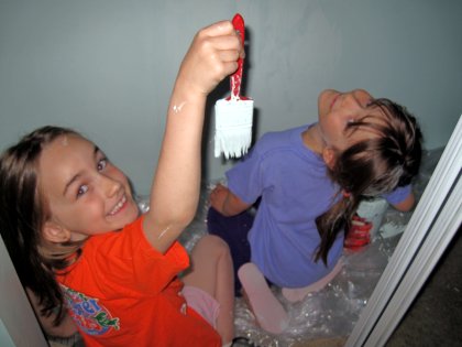 Two girls painting in a closet
